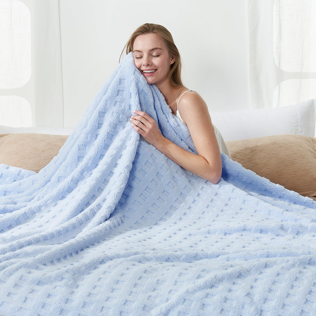 Woman holding a checkered waffle shaggy sherpa throw blanket in Blue, enjoying soft and cozy comfort #color_Cool Blue