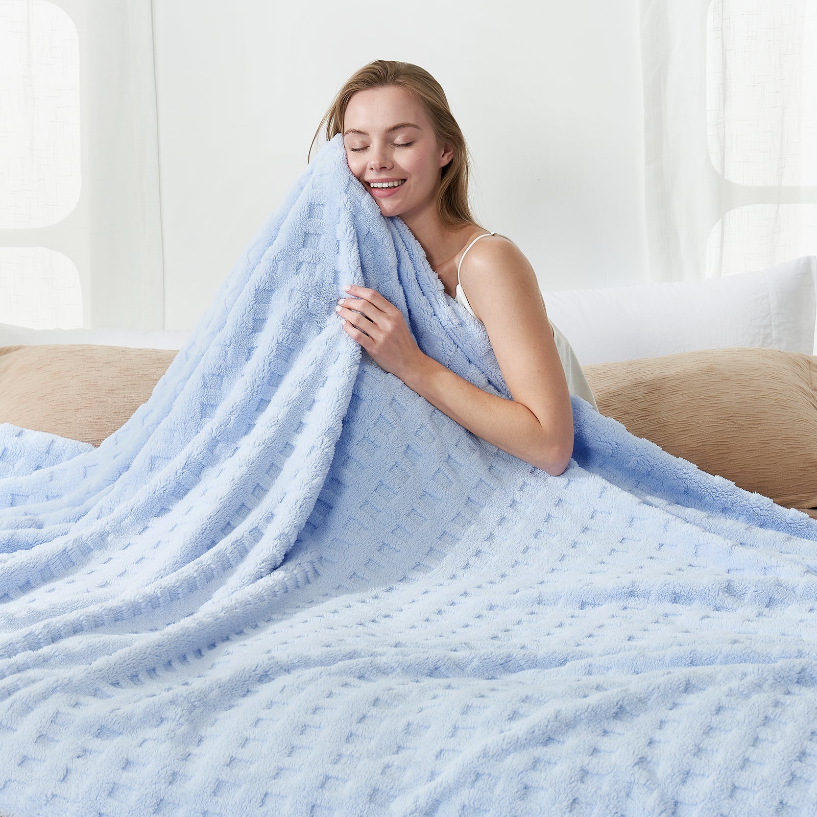 Woman holding a checkered waffle shaggy sherpa throw blanket in Blue, enjoying soft and cozy comfort #color_Cool Blue