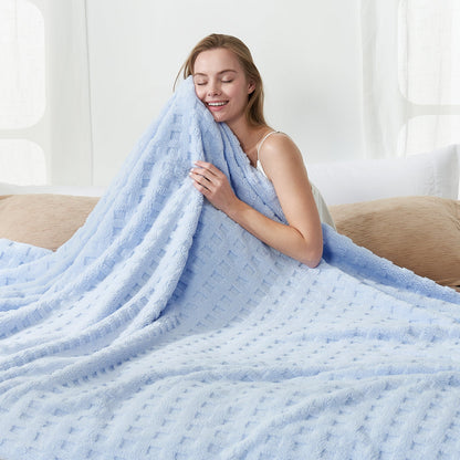 Woman holding a checkered waffle shaggy sherpa throw blanket in Blue, enjoying soft and cozy comfort #color_Cool Blue