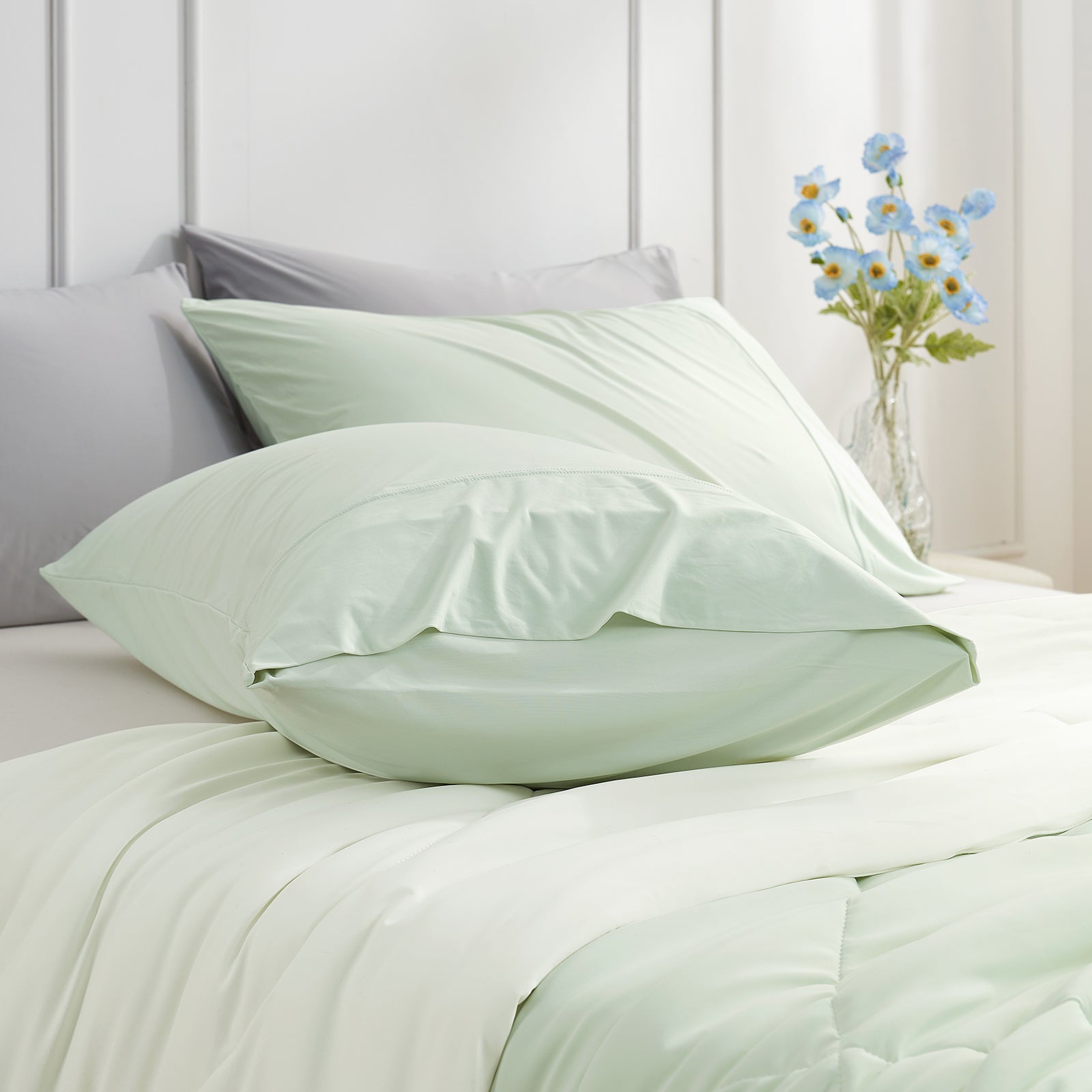 Cooling pillowcases in mint green on a bed. Breathable, soft bedding for comfortable sleep. #color_Light Mint Green