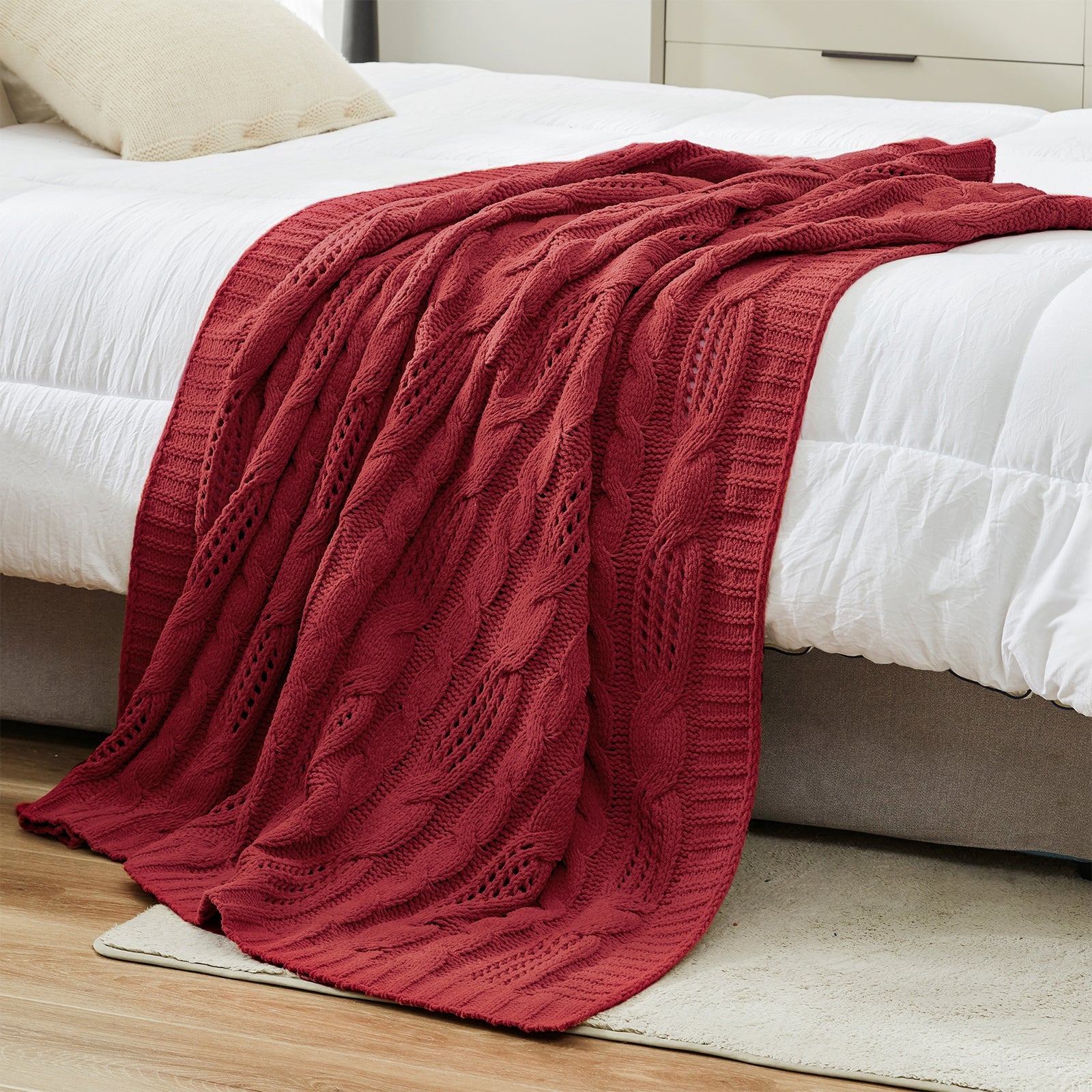 Chenille Cable Knit Throw Blanket in Red styled on a bed in a modern bedroom, adding warmth and a bold cozy look. #color_Red