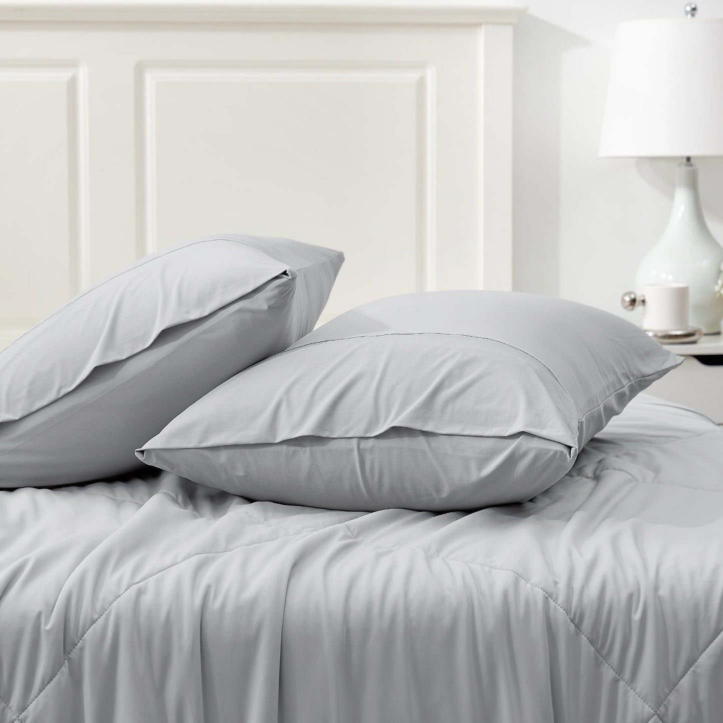 Gray Cooling Pillowcases set on a bed, breathable and comfortable bedding for hot sleepers. #color_Light Grey