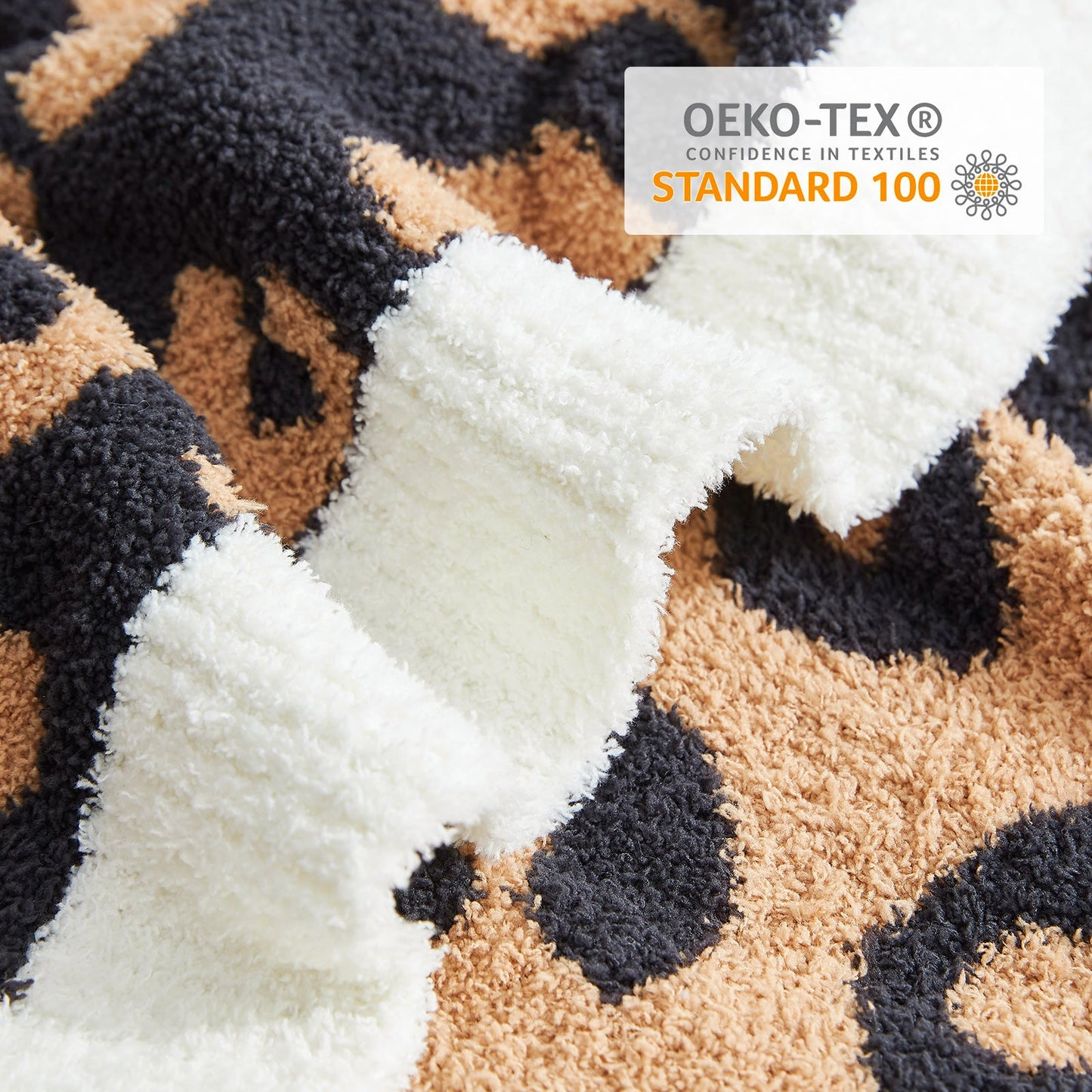 Close-up of Reversible Leopard Feather Yarn Throw Blanket in Black showcasing soft texture and OEKO-TEX STANDARD 100 certification. #color_Black