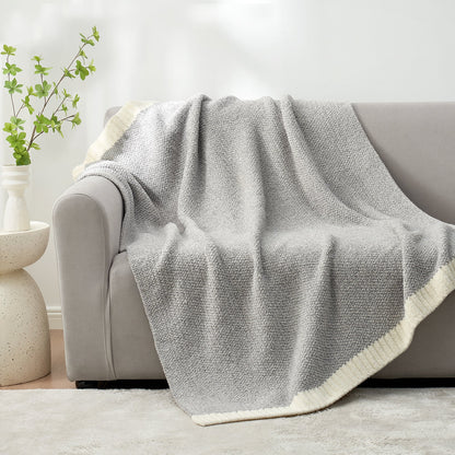 Heather Feather Yarn Throw Blanket in Grey draped over a sofa, adding warmth, softness and a modern cozy touch to your living room. #Color_Grey