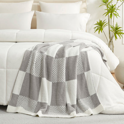 Checkered Feather Yarn Throw Blanket in Grey styled on a bed, adding a clean and cozy layered look to bedroom decor. #color_Grey