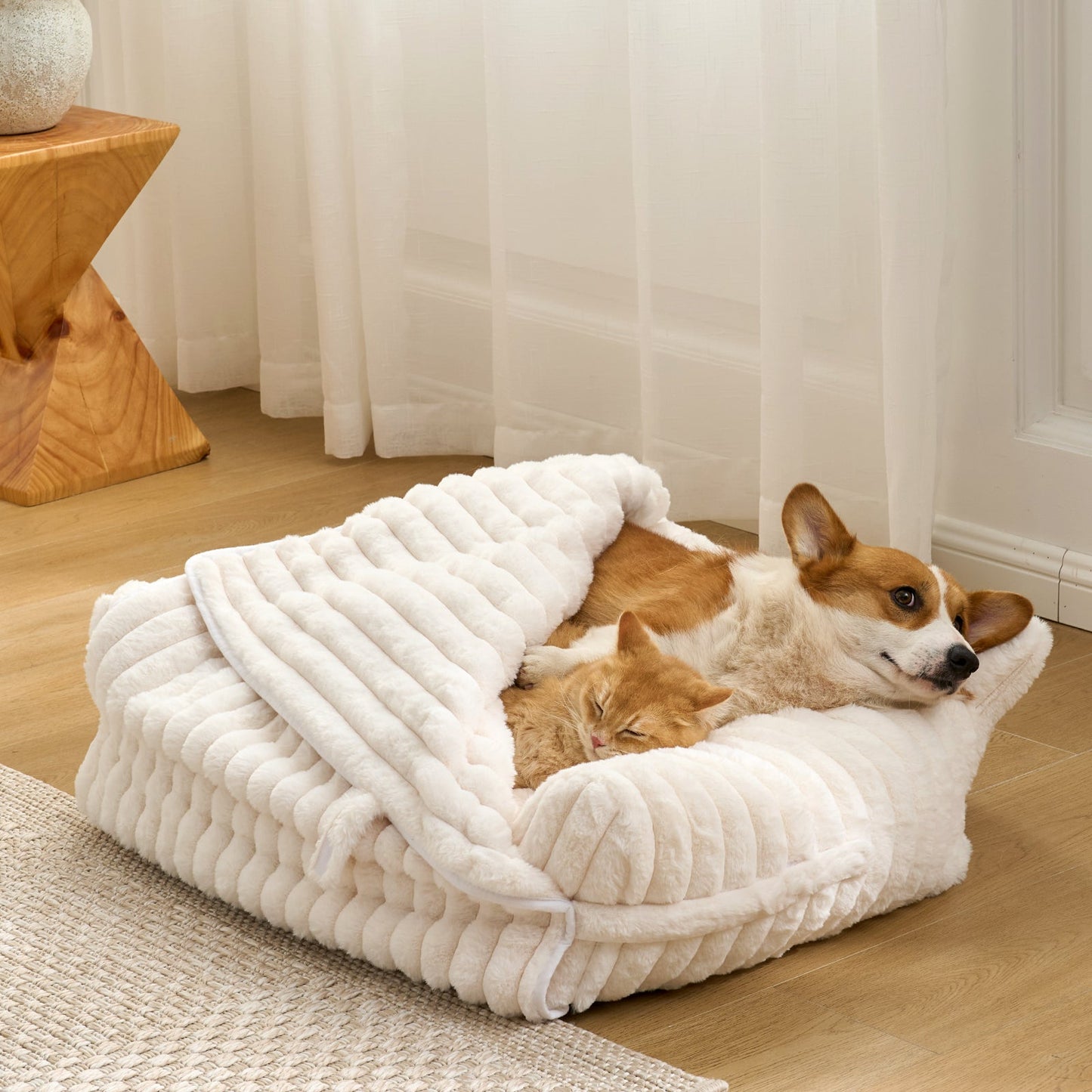  Corgi and Cat, lying on a fluffy white faux fur pet bed in a cozy room.#color_Cream White