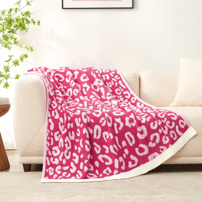 Reversible Leopard Feather Yarn Throw Blanket in Hot Pink draped over a sofa, highlighting its plush faux fur feel. #color_Hot Pink